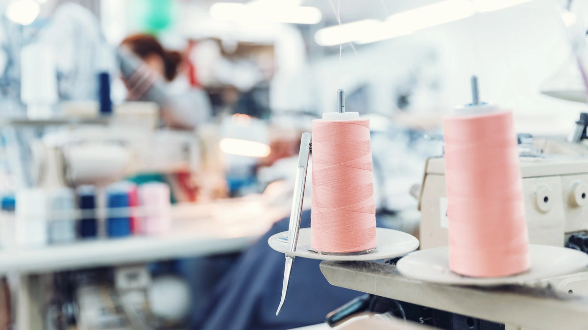 Focus sur des bobinnes de fils rose dans un atelier de couture