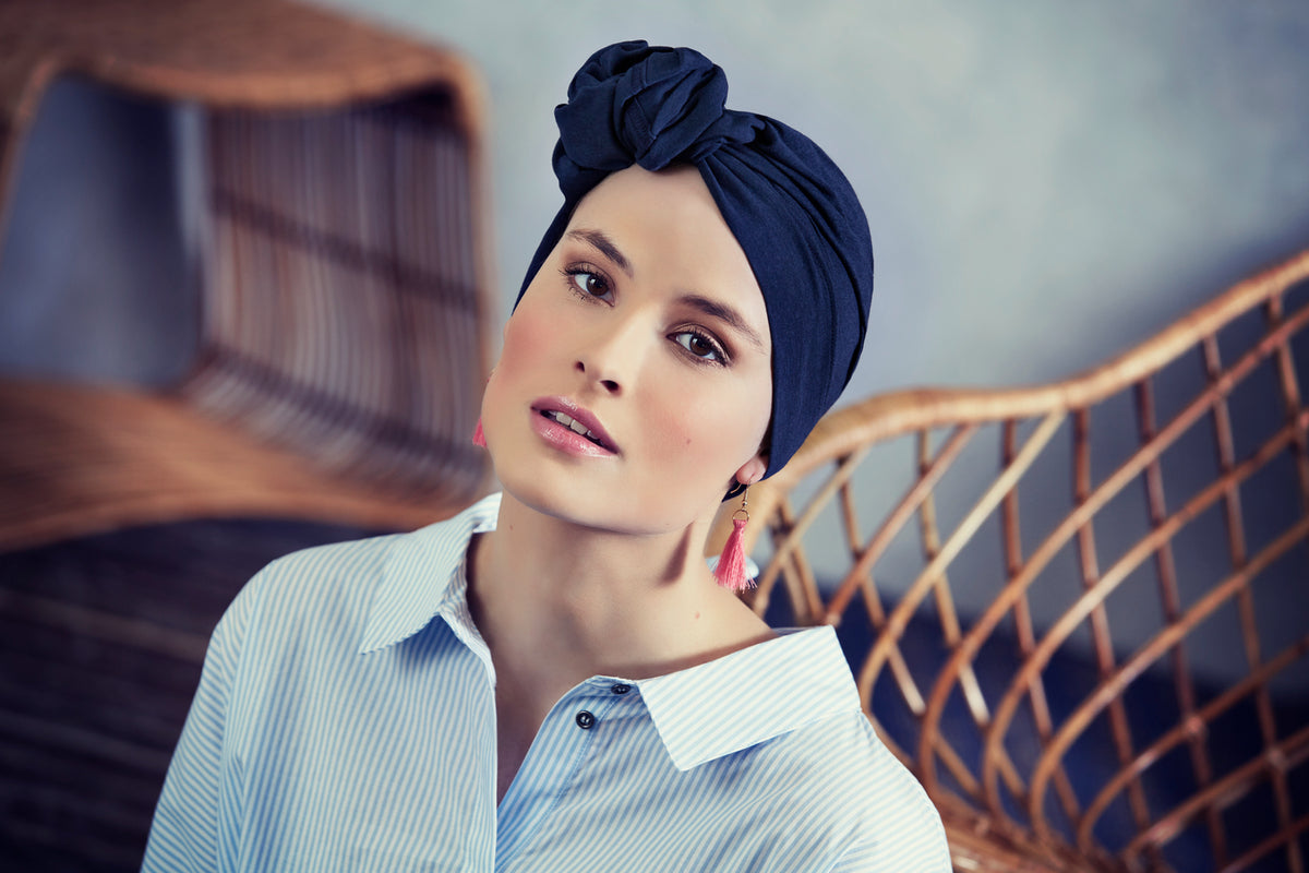 Femme portant un foulard chimio en tube Sibelle bleu marine noué sur la tête