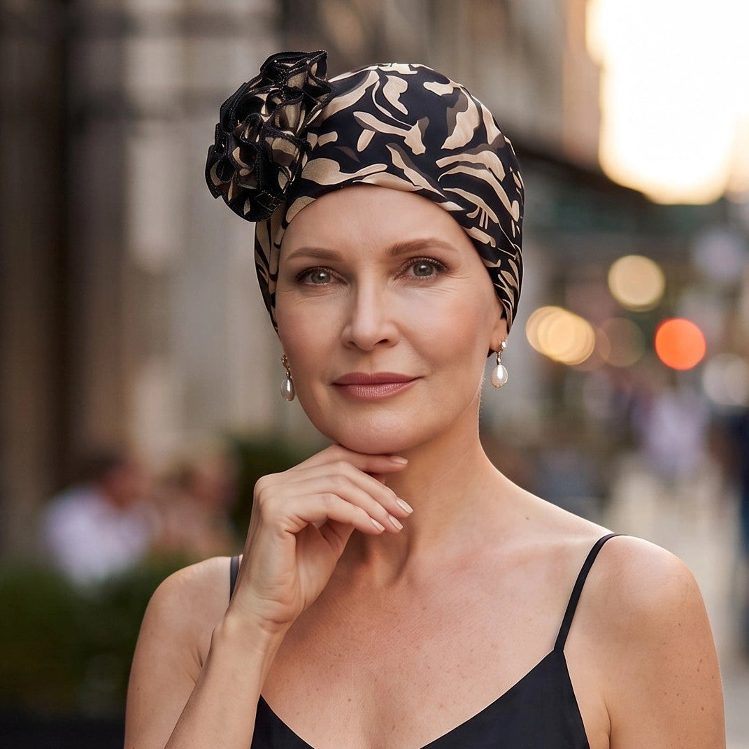 Femme vivant avec une perte de cheveux du au cancer ou à la chimiothérapie avec un bonnet flora brazil noir Sibelle en ville