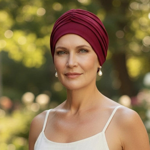Femme vivant avec une perte de cheveux du au cancer ou à la chimiothérapie avec un bonnet twist en bambou rubi Sibelle dans un parc l'automne