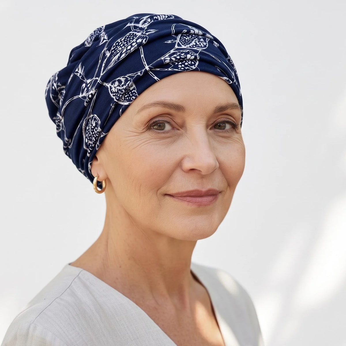 Femme vivant avec une perte de cheveux du au cancer ou à la chimiothérapie avec un bonnet twist brazil bleu Sibelle à l'extérieur
