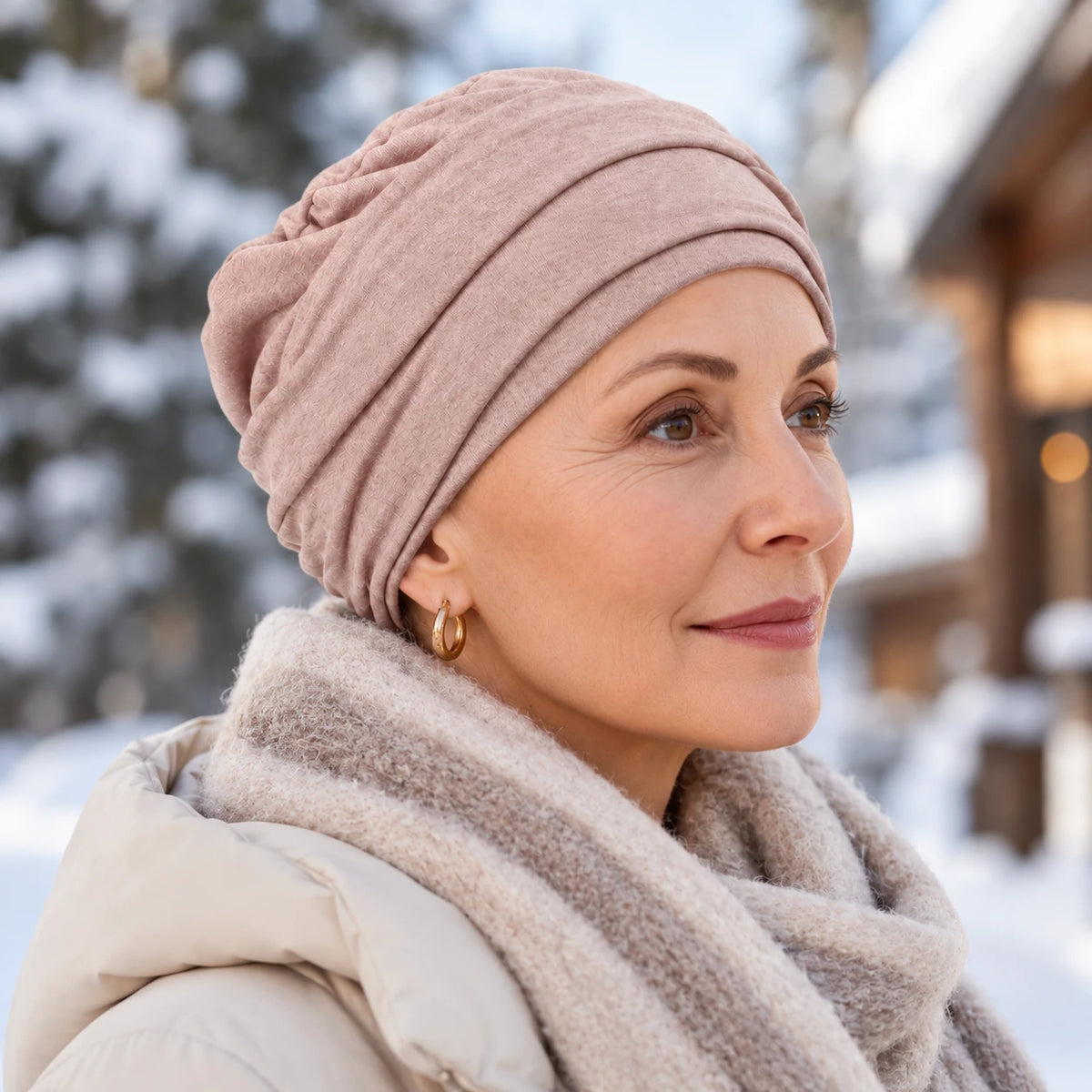 Femme confronté à la perte de ses cheveux du au cancer ou à la chimiothérapie portant un bonnet twist en tricot rose.