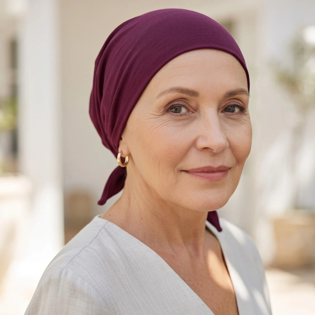 Femme vivant avec une perte de cheveux du au cancer ou à la chimiothérapie avec un foulard rétro en bambou rubi Sibelle à l'etxérieur