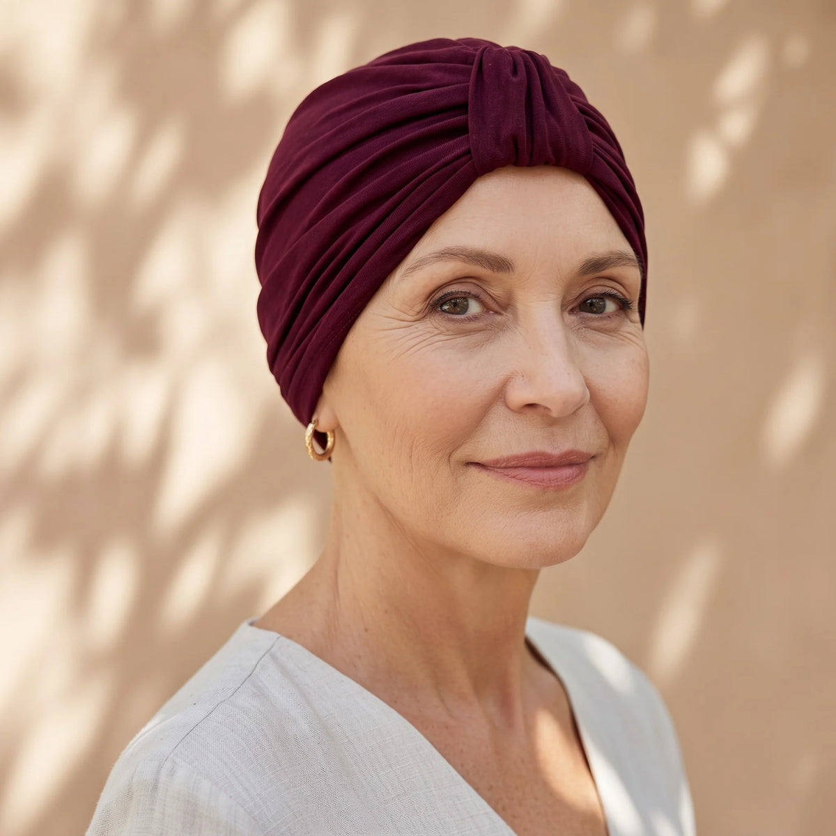 Femme vivant avec une perte de cheveux du au cancer ou à la chimiothérapie avec un turban urbain en bambou rubi Sibelle à l'extérieur